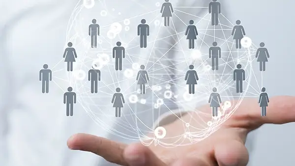 KI-generiertes Bild - Hand hält visualisiertes Netzwerk aus verbundenen Personen-Icons, symbolisiert Kommunikation, Zusammenarbeit und digitale Vernetzung im modernen Geschäftsumfeld von Pecos.